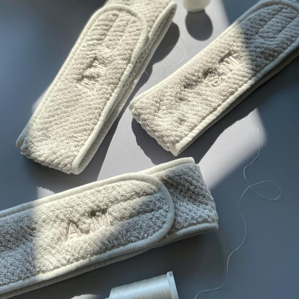 Personalised embroidered cream headbands on table with thread, modern Ineedledit gift.