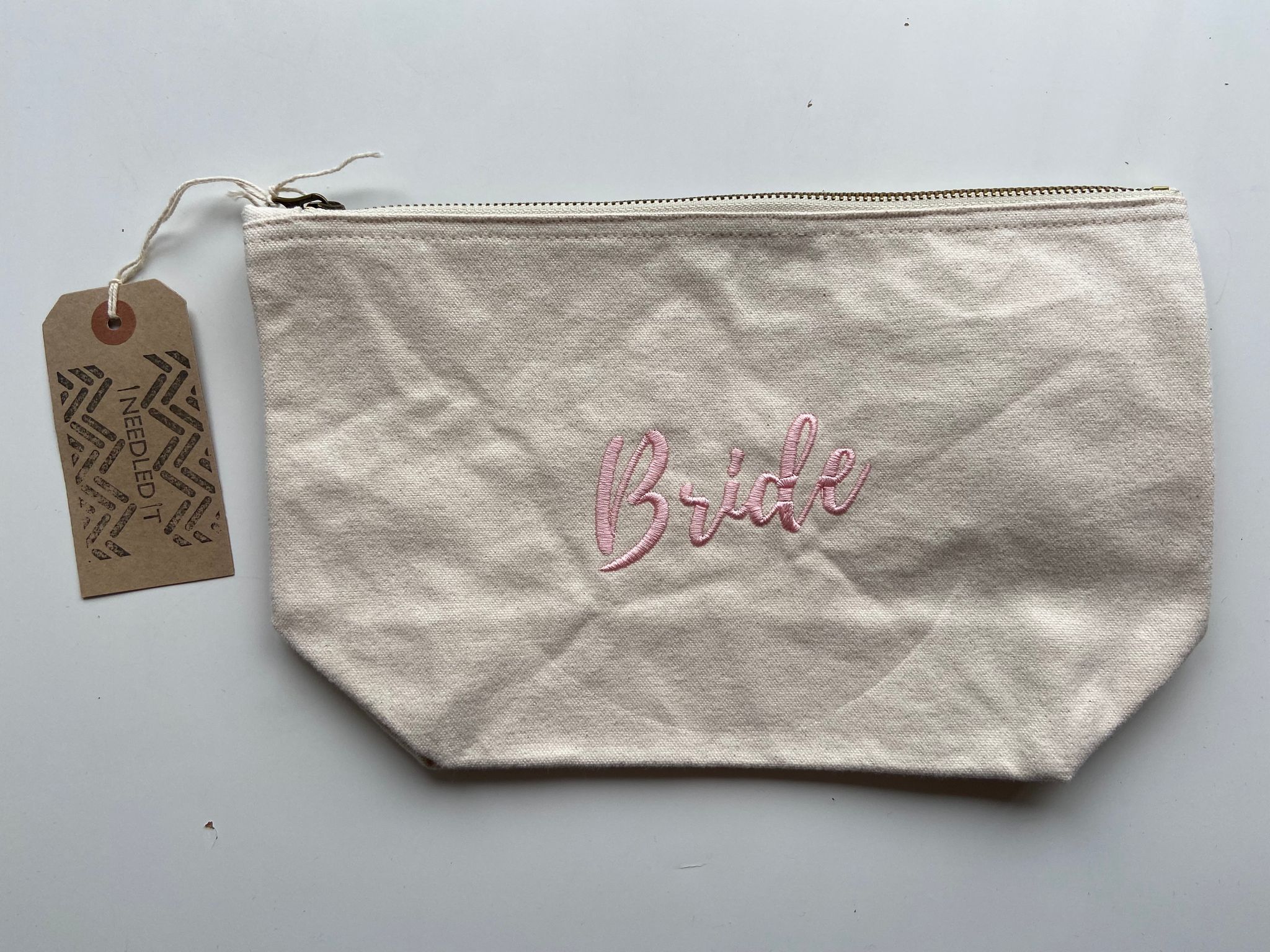 Personalised embroidered bride pouch by Ineedledit, cream fabric with pink stitching and tag