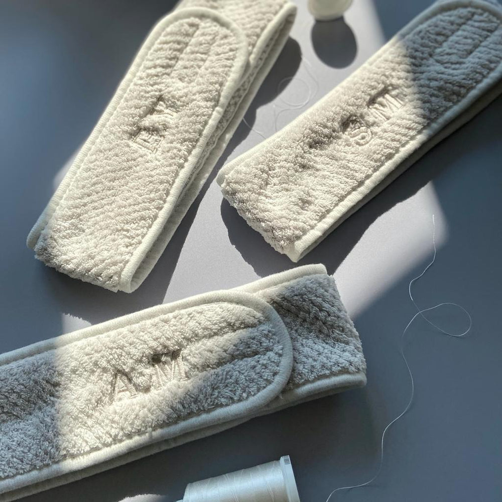 Personalised embroidered cream headbands on table with thread, modern Ineedledit gift.