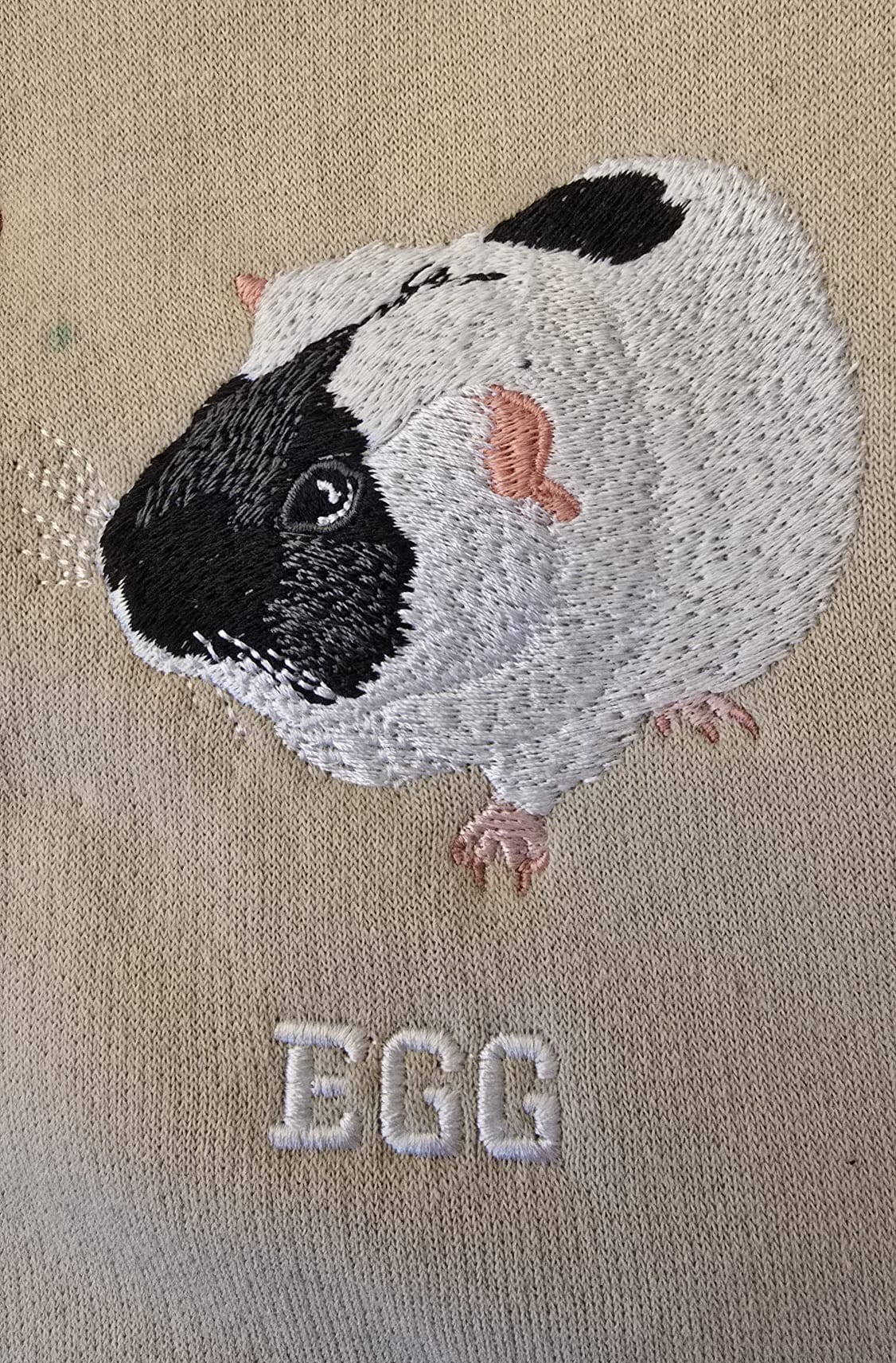 Personalised guinea pig embroidery with black and white fur and name Egg on beige fabric